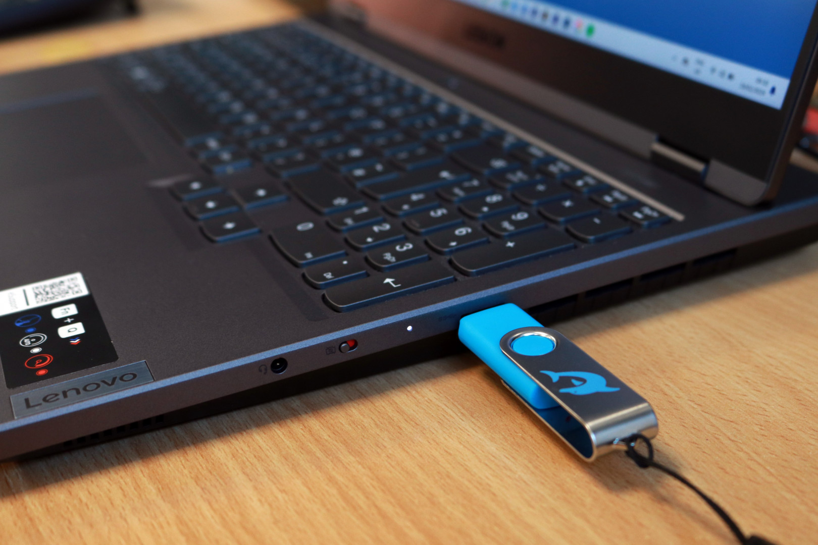 A Dolphin USB is being plugged into a laptop.